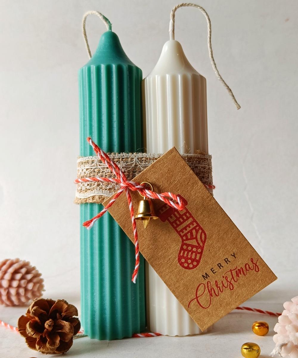 Decorative candles with a 'Merry Christmas' tag on a light background