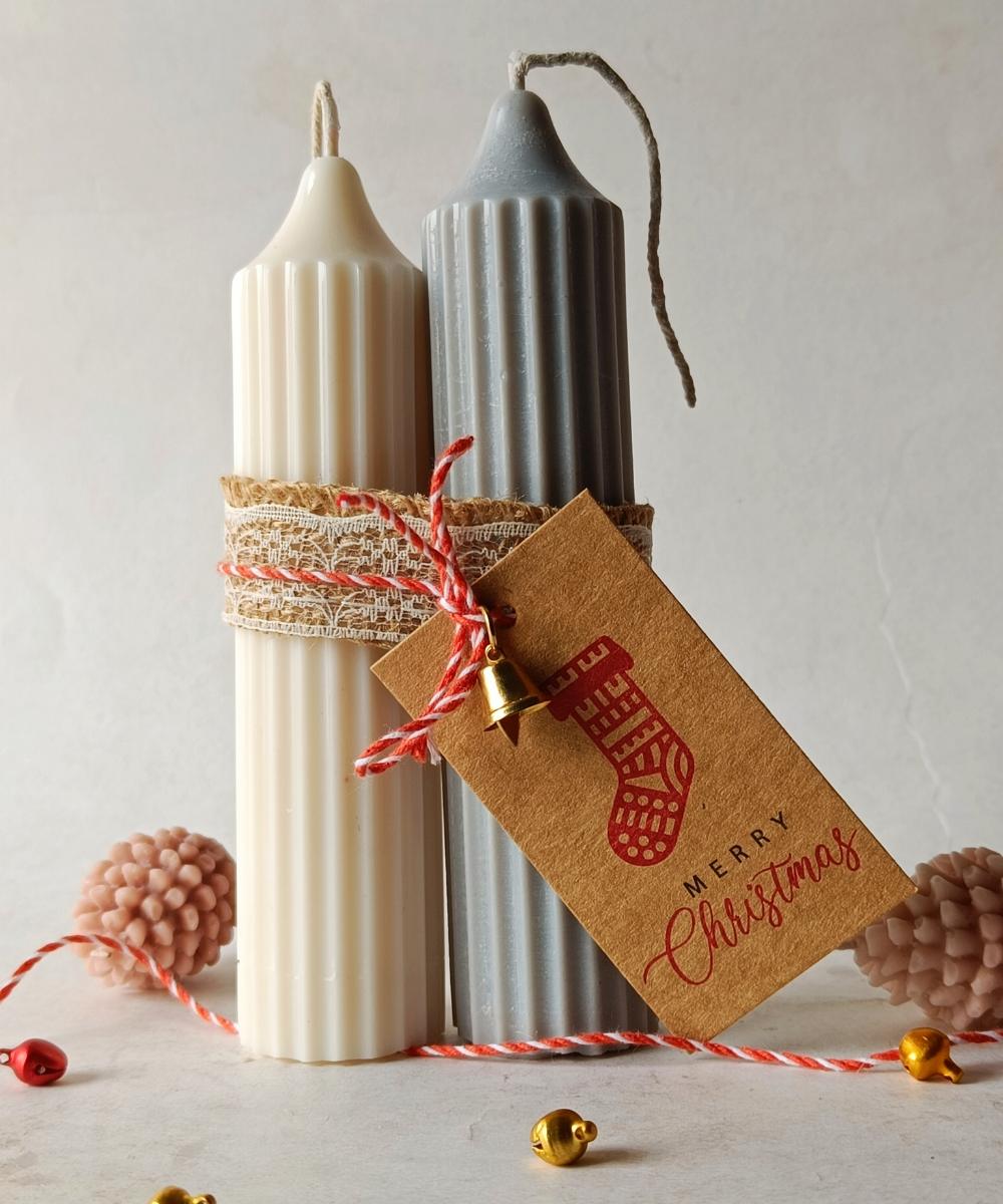 Decorative candles with a 'Merry Christmas' tag on a light background