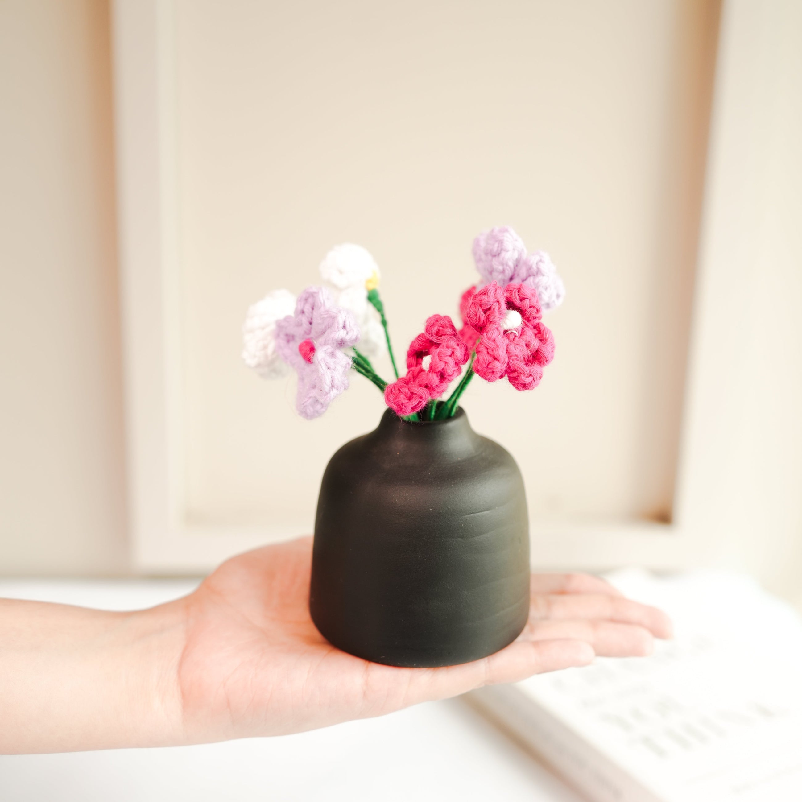 black bud vase with mini crochet daisies