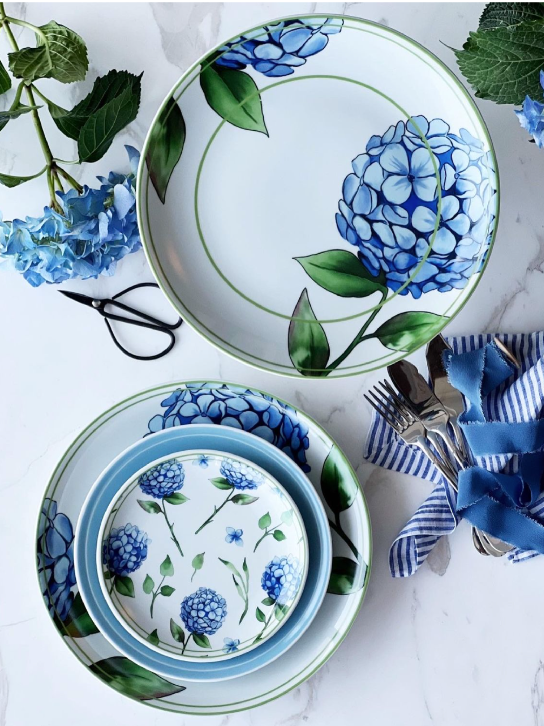 Set of ceramic plates with blue floral design on a white surface with decorative elements.