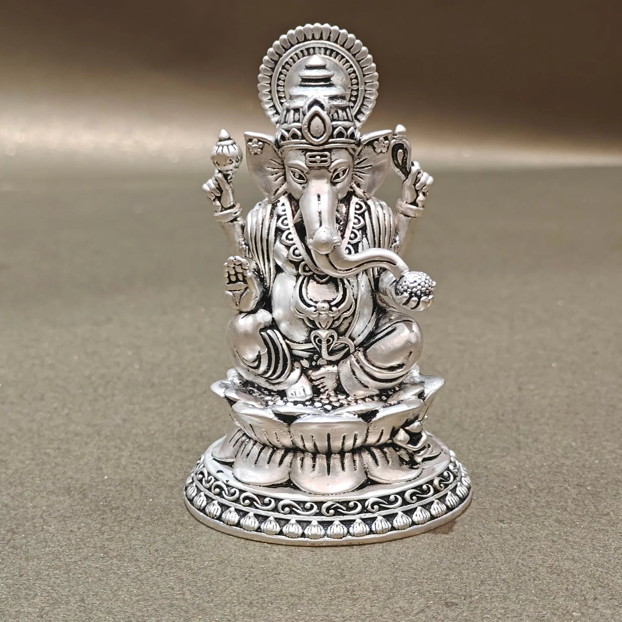 Silver Ganesh idol with intricate detailing on a plain background, Sabera store homepage