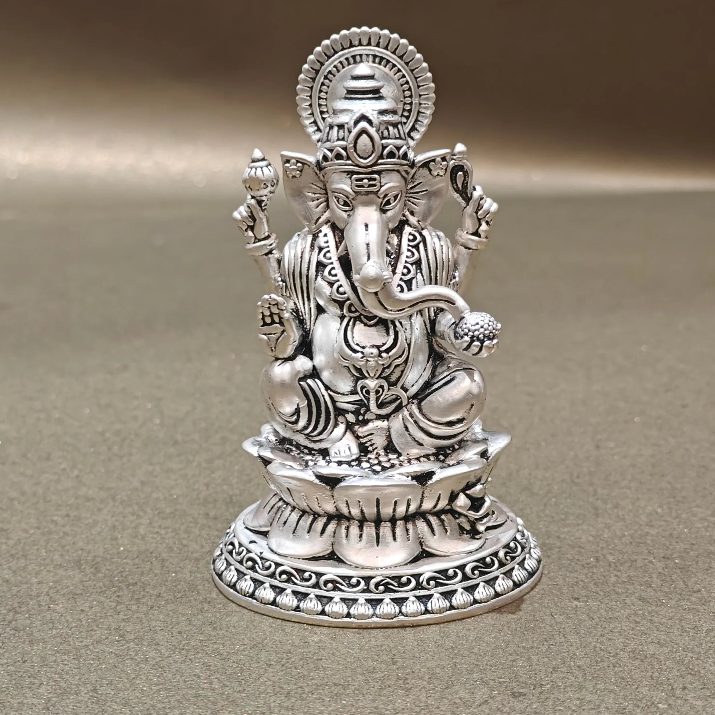 Silver Ganesh idol with intricate detailing on a plain background, Sabera store homepage