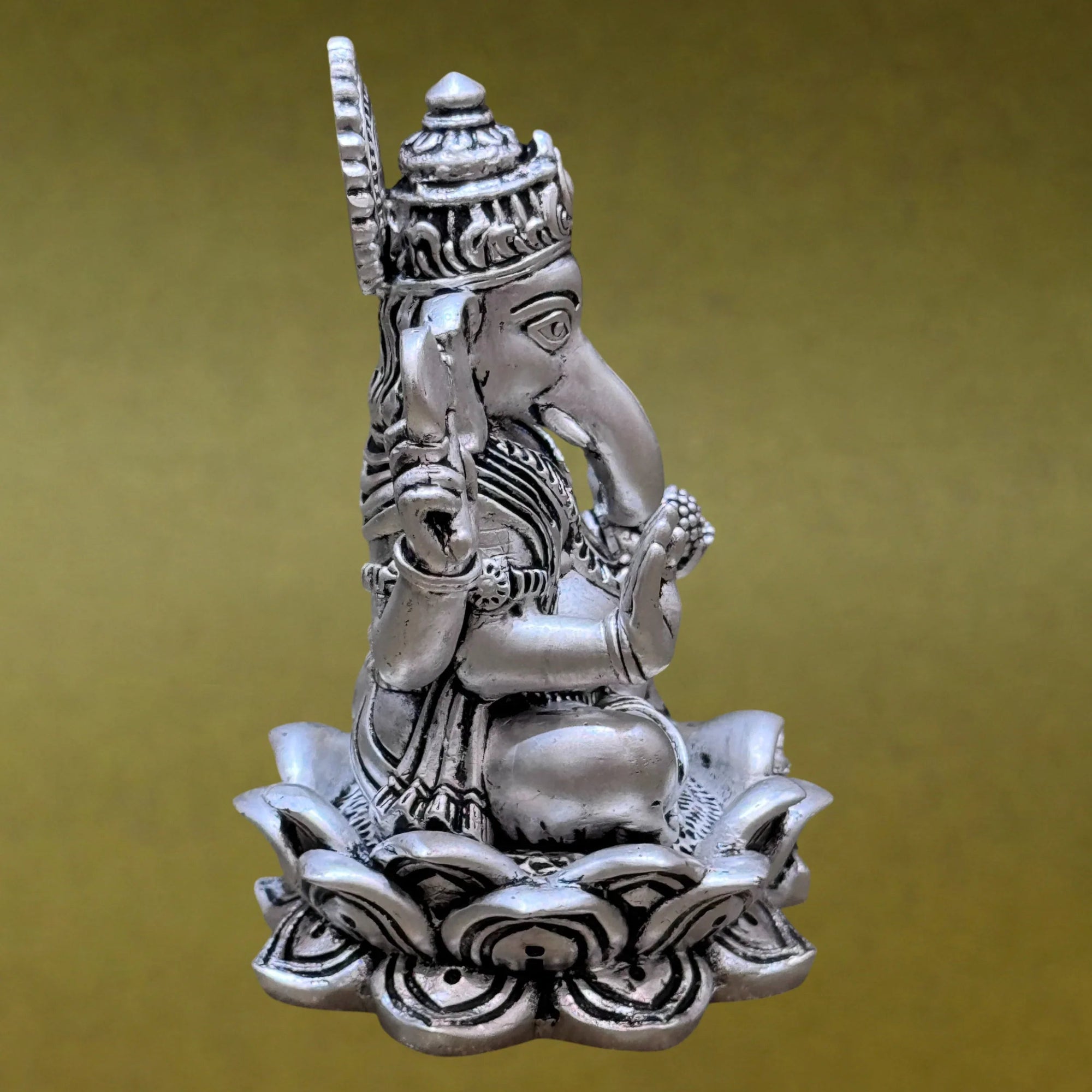 Silver Ganesha idol seated on lotus, Sabera decor, brass finish, yellow background