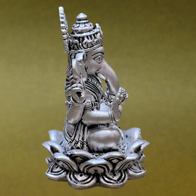 Silver Ganesha idol seated on lotus, Sabera decor, brass finish, yellow background