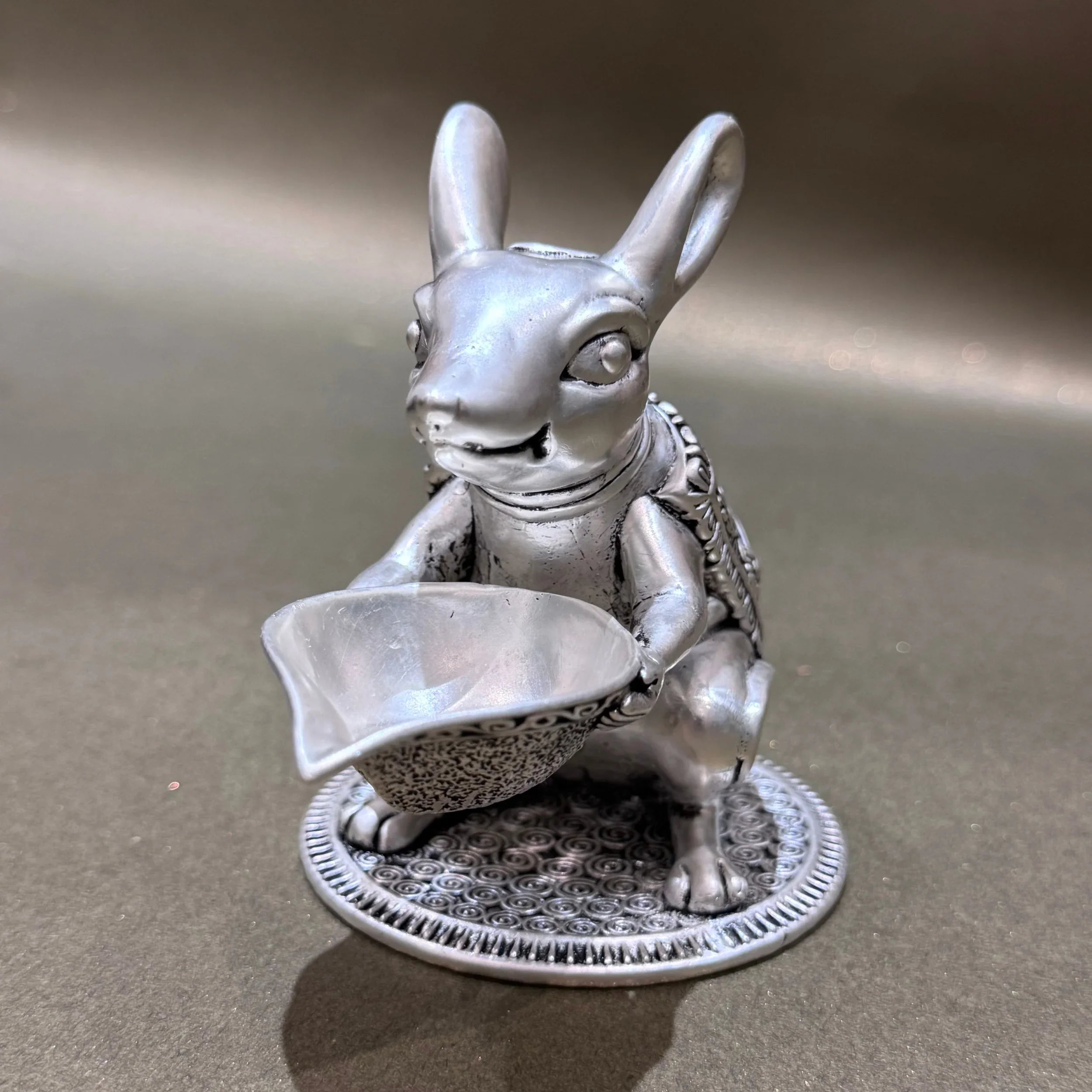 Silver rabbit figurine with detailed base holding bowl, product photography for Sabera