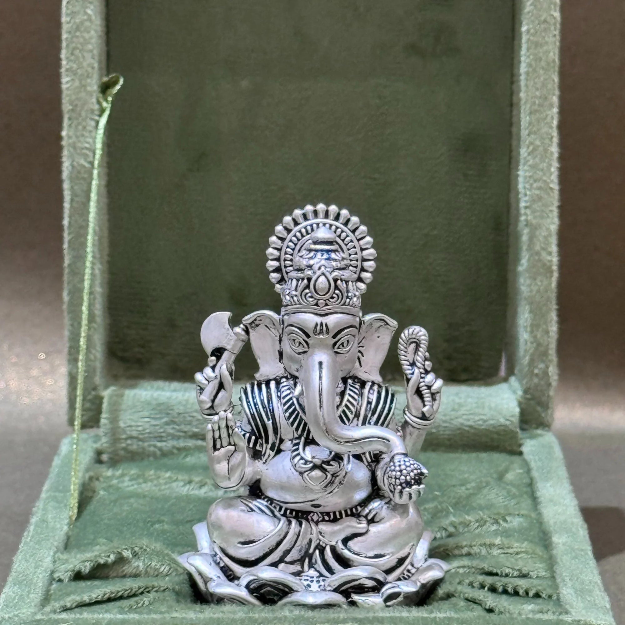 Silver Ganesh idol in ornate gift box, collectible decor available at Sabera