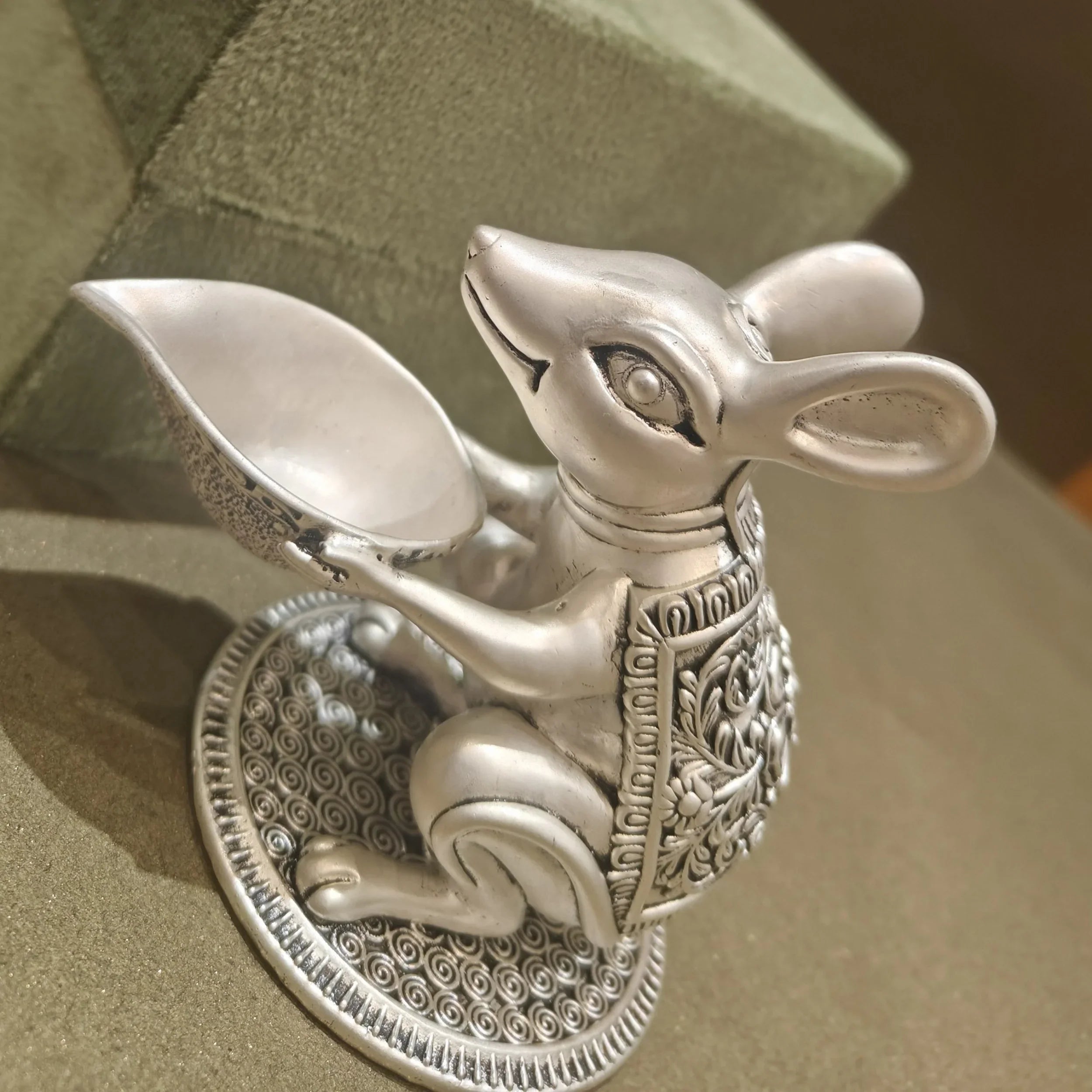 Ornate silver mouse idol holding bowl, decorative Sabera home decor on green background
