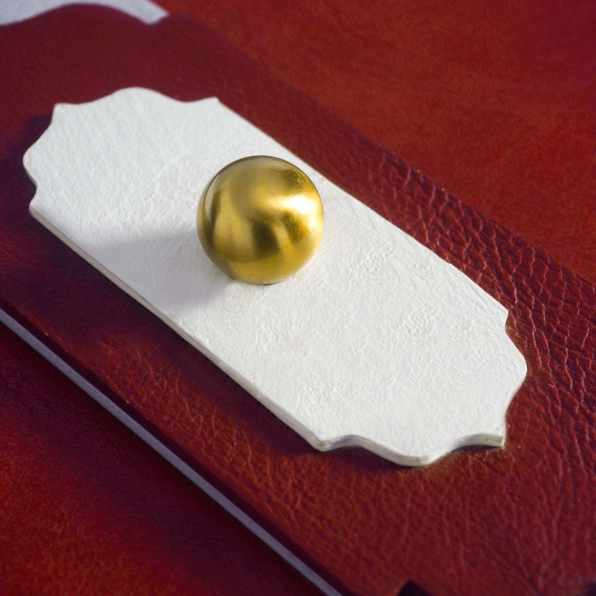 Red leather knob box close up golden brass knob detail - The Mage Home