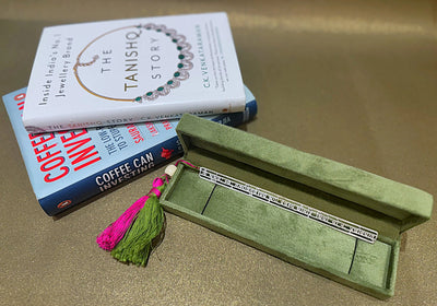 Sabera jewelry piece in green box with pink tassel, next to books The Tanishq Story and Coffee Can Investing