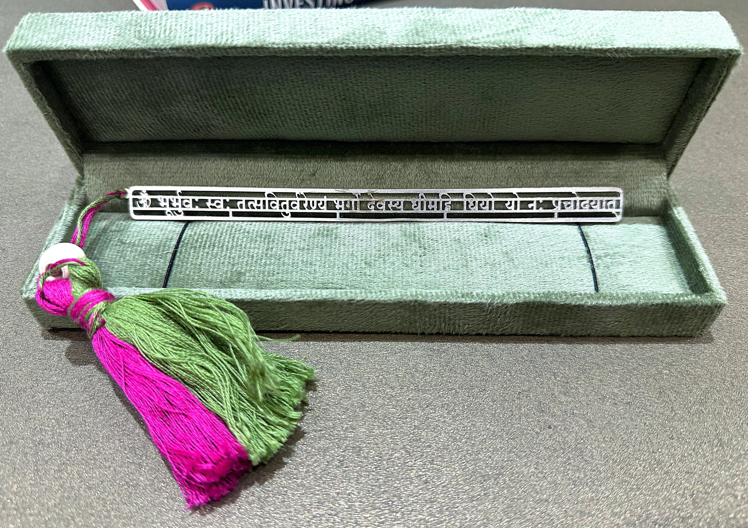 Silver Hindi script bookmark with green and magenta tassel in a green velvet box, Sabera