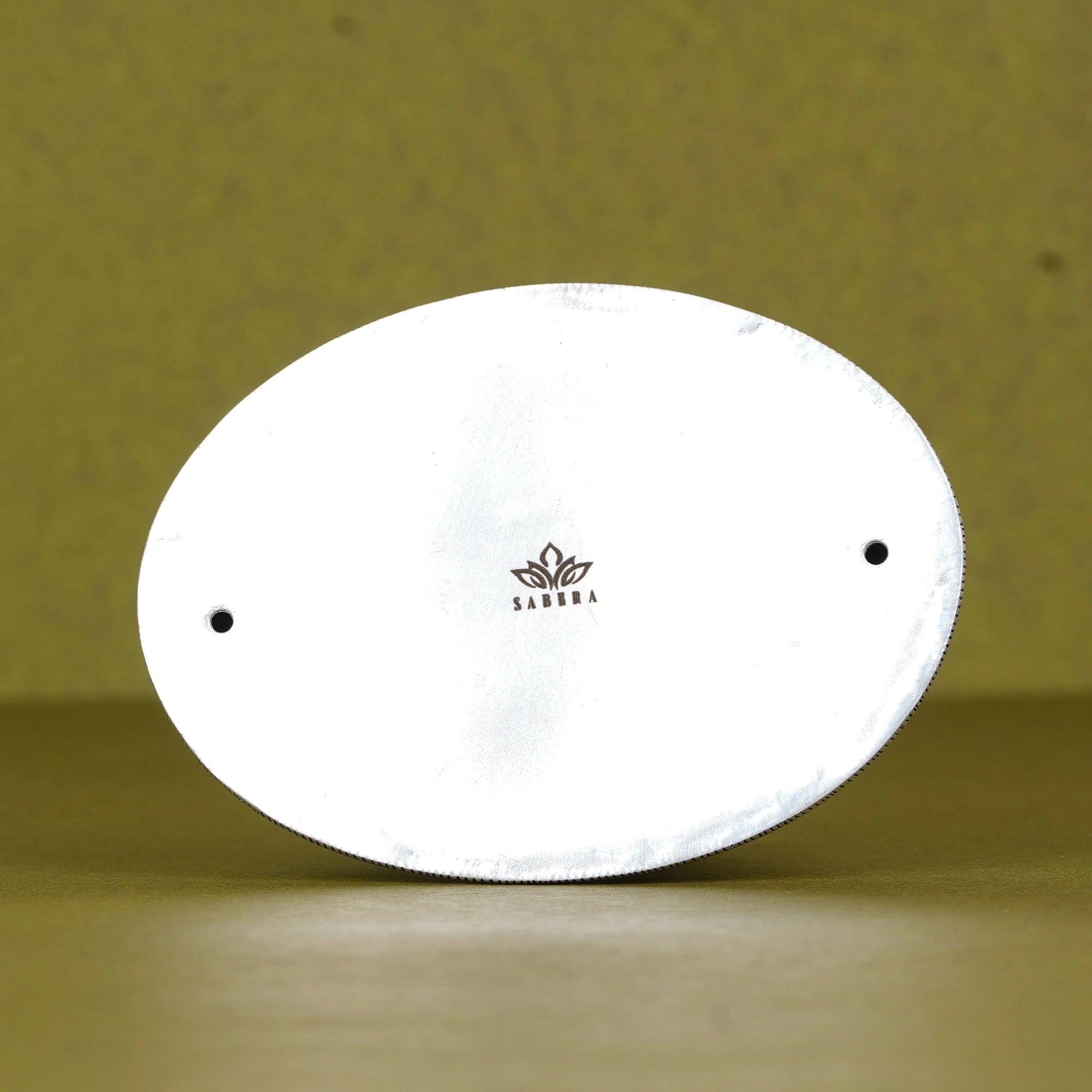 Back view of white oval Adiyogi Shiva idol base with Sabera logo, on olive background