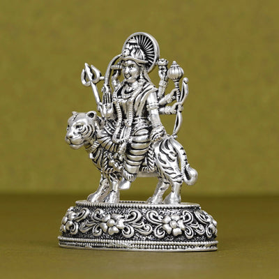 Silver Durga idol riding a tiger, detailed car dashboard decor on ornate base, Sabera