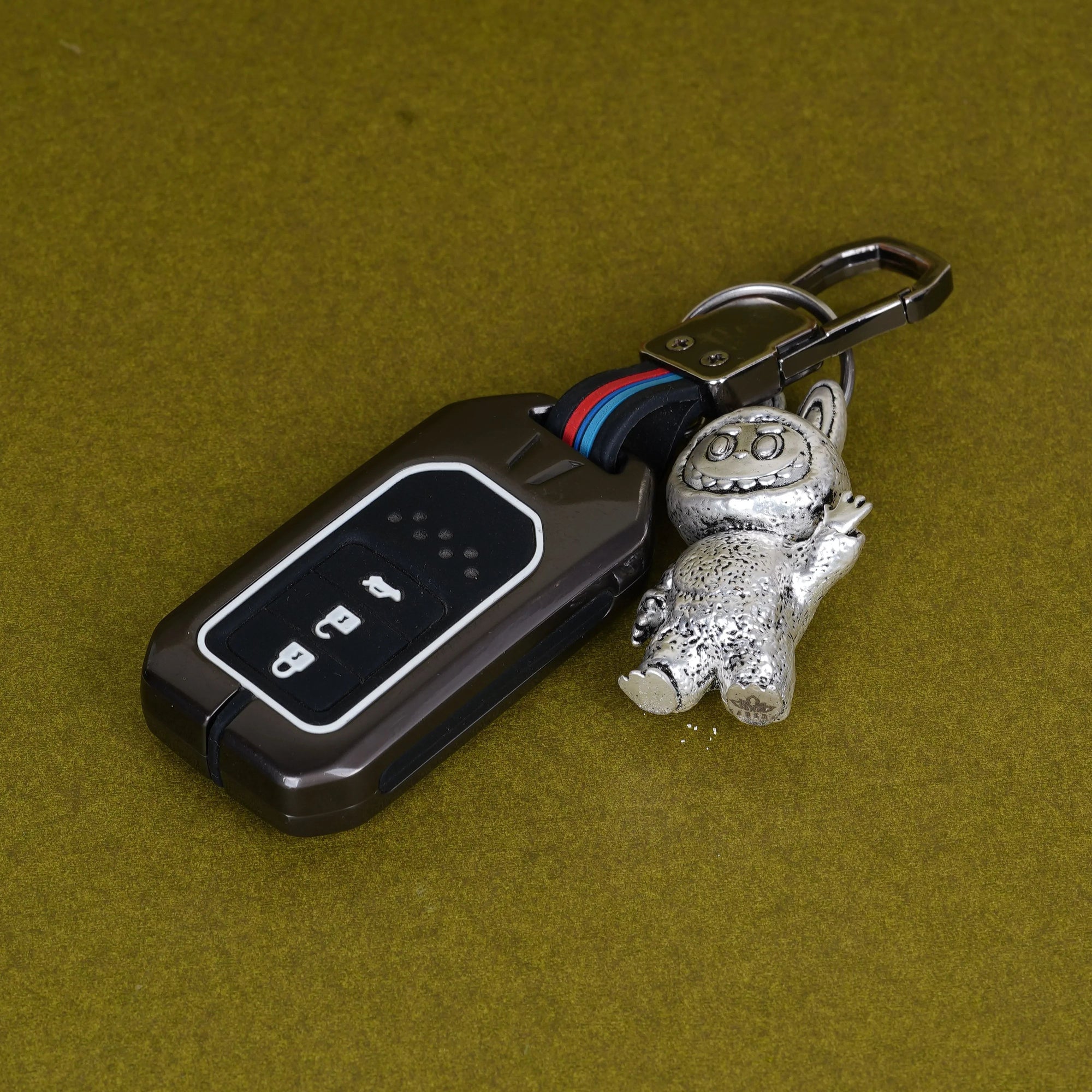 Elegant Labubu silver plated 3D keychain with car key on olive background, Sabera