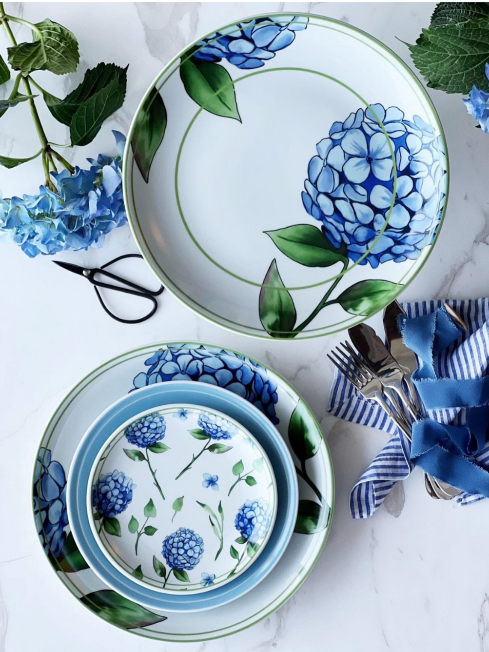 Set of ceramic plates with blue floral design on a white surface with decorative elements.