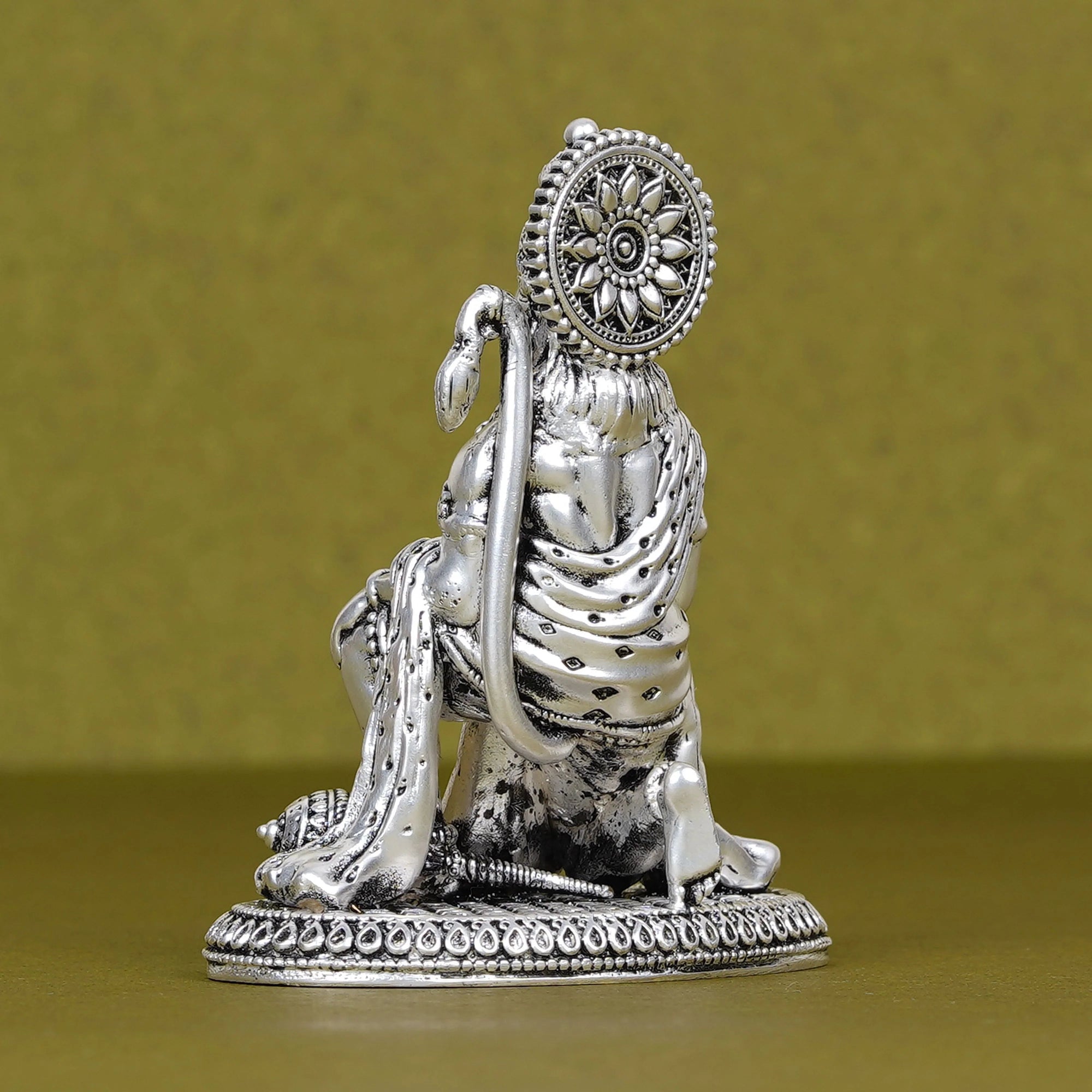Silver Hanuman idol for car dashboard on Sabera, detailed with halo and tail, against gold background