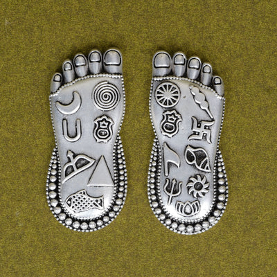 Lakshmi Charan foot silver charm on square wooden base, close view