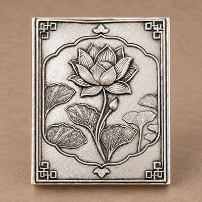 Silver-plated brass lotus matchbox cover standing upright, showing the hand-antiqued background