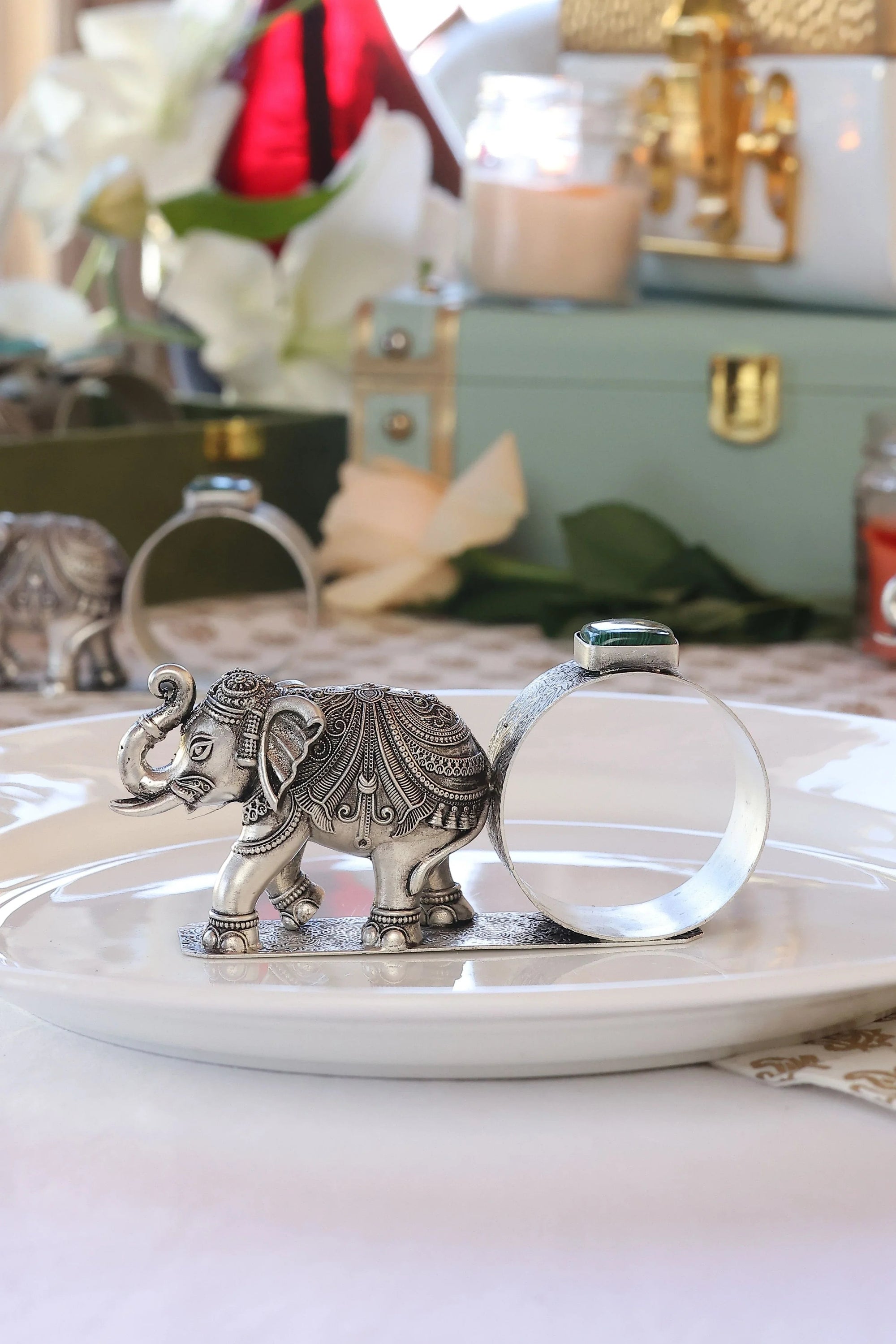 Sabera antique silver elephant napkin ring with ornate design on a white plate, stone accent