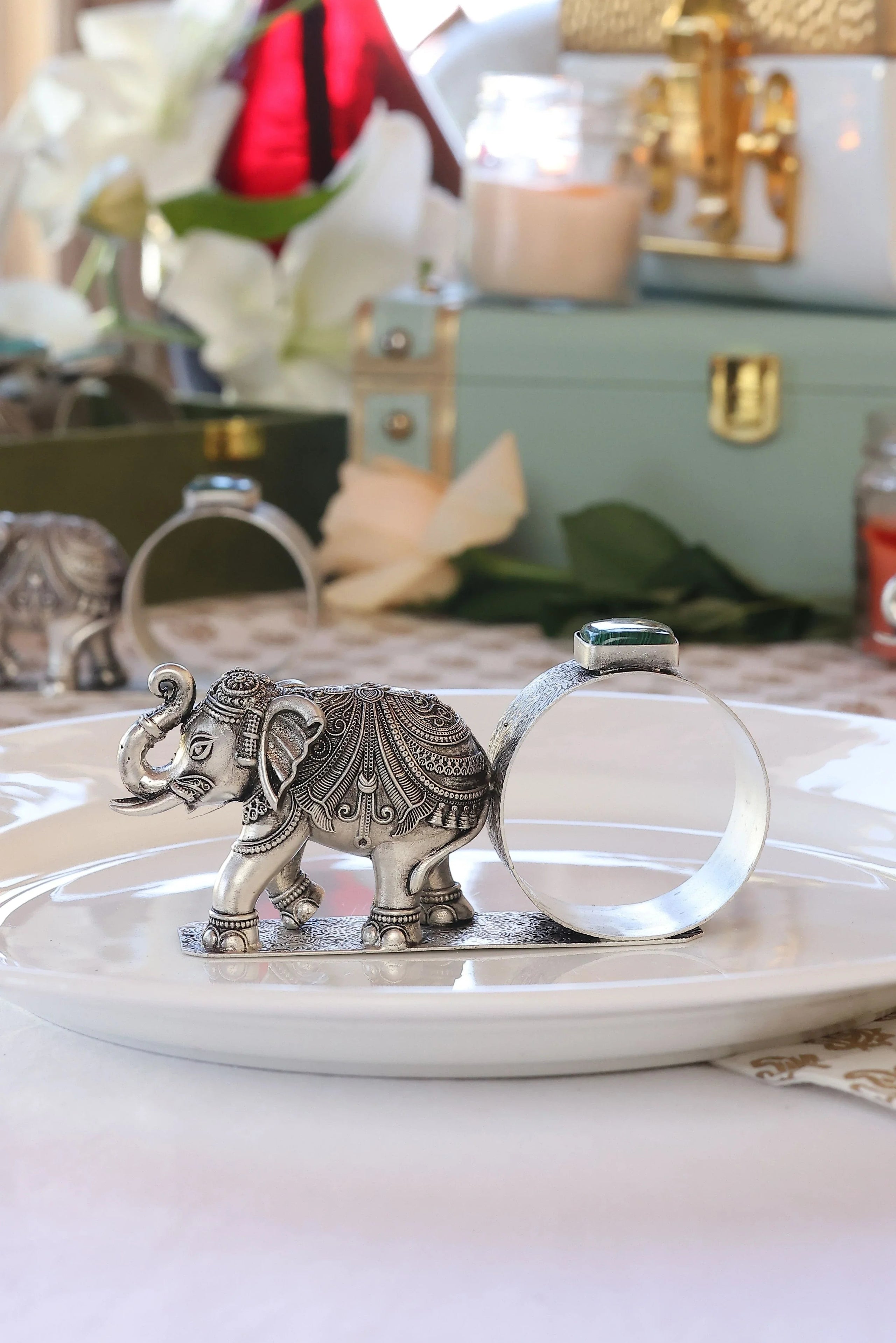 Sabera antique silver elephant napkin ring with ornate design on a white plate, stone accent