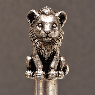 Close view of the lion cub's face, mane and paws in pure silver plating on a high-grade brass base