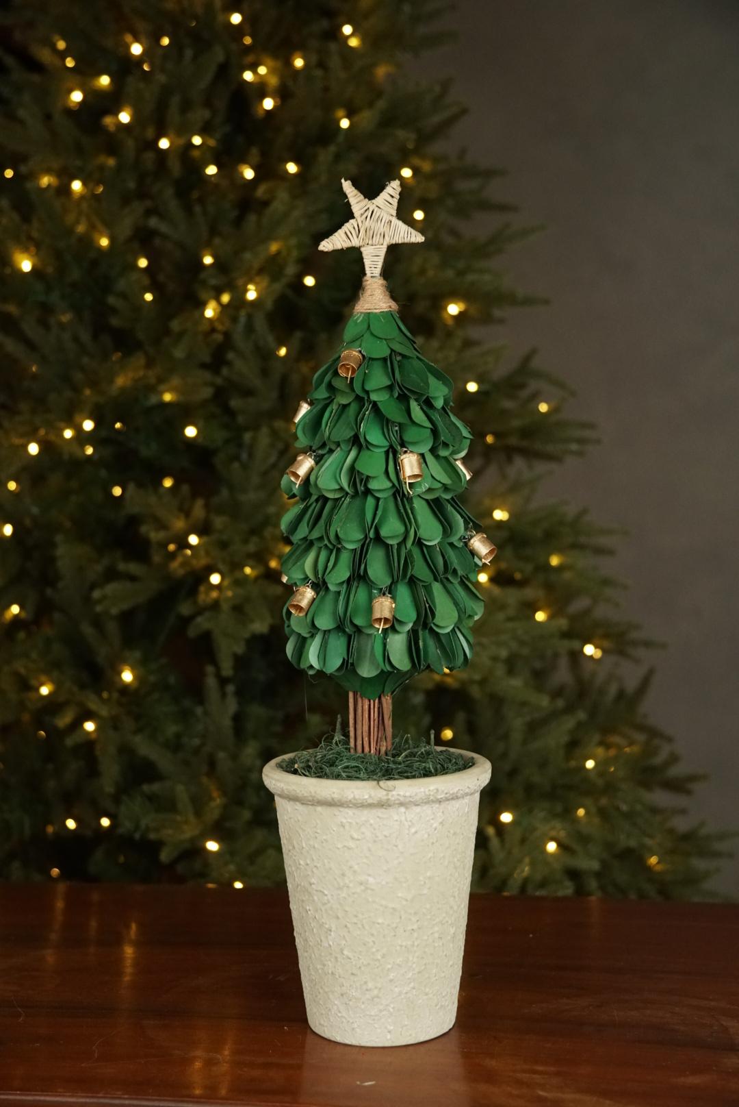 Handmade Xmas tree with natural materials and ceramic vase decorated with bells and wicker star