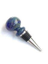 A blue glass wine bottle stopper with a stainless steel fixture, designed to fit on a narrow mouth bottle.